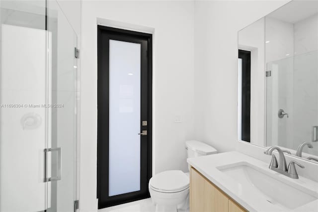 bathroom featuring vanity, toilet, and an enclosed shower