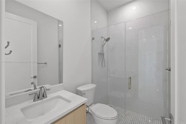 bathroom featuring vanity, toilet, and a shower with shower door