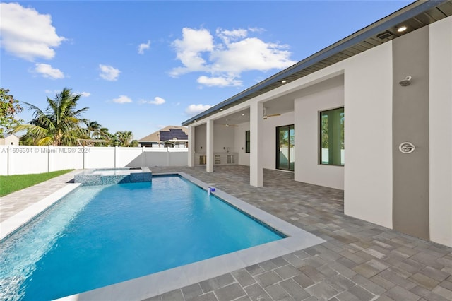 view of swimming pool featuring ceiling fan, a patio area, and an in ground hot tub