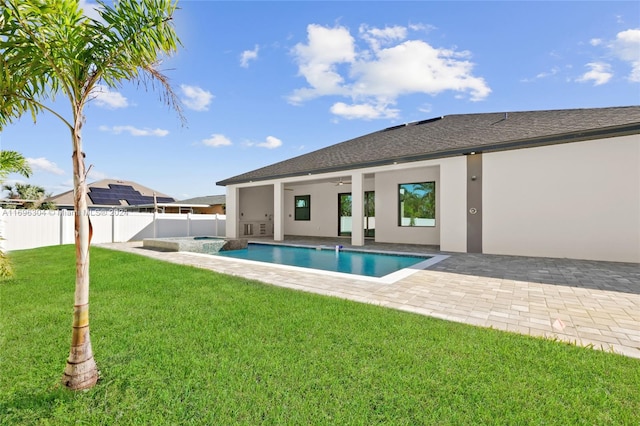 back of property with a fenced in pool, ceiling fan, a yard, and a patio