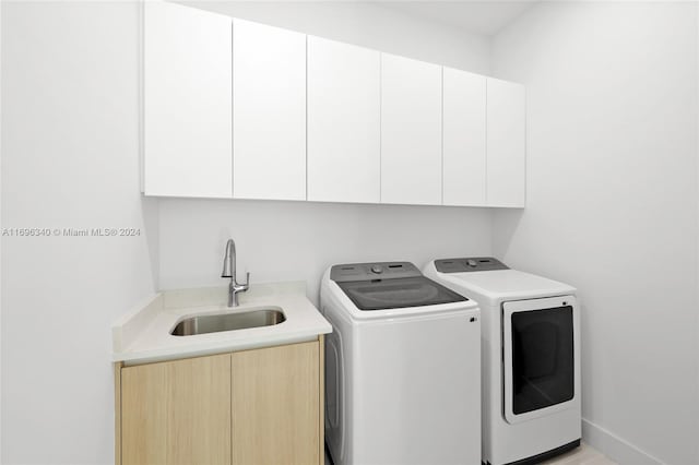 washroom with sink, cabinets, and independent washer and dryer