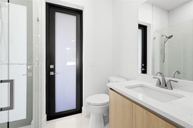 bathroom featuring tile patterned floors, vanity, an enclosed shower, and toilet