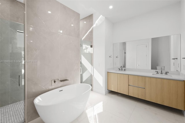 bathroom with vanity, shower with separate bathtub, and tile walls