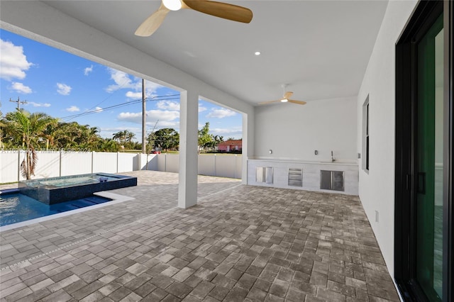 view of patio / terrace featuring ceiling fan and a pool with hot tub