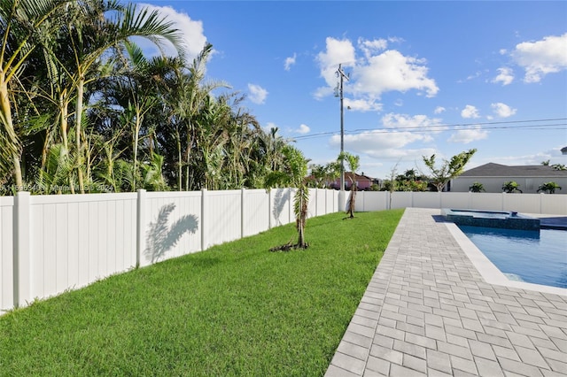 view of yard featuring a swimming pool with hot tub