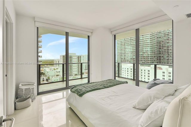 bedroom featuring access to outside, floor to ceiling windows, and light tile patterned flooring