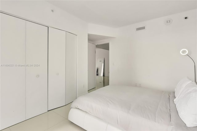 bedroom with a closet and light tile patterned flooring