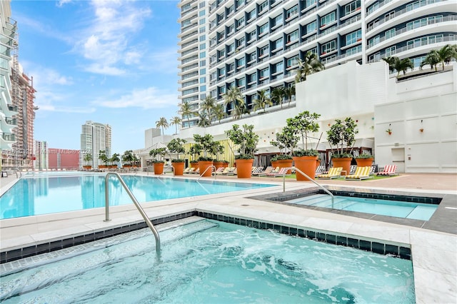 view of swimming pool featuring a hot tub