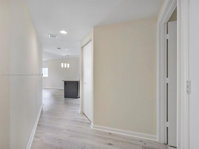 hallway with light hardwood / wood-style floors