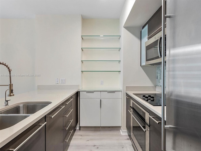 kitchen with white cabinets, sink, light wood-type flooring, and stainless steel appliances