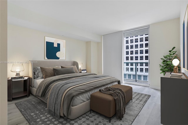 bedroom featuring light hardwood / wood-style flooring and a wall of windows