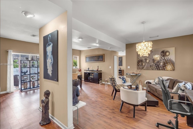 living room with hardwood / wood-style flooring and a notable chandelier