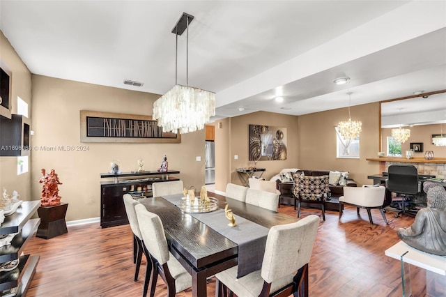 dining space with wood-type flooring and an inviting chandelier