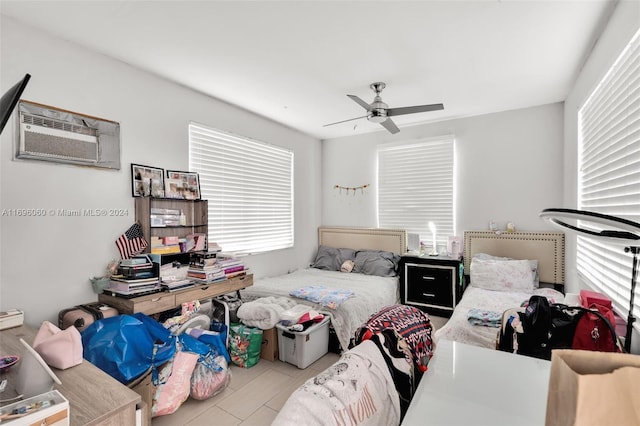 bedroom featuring ceiling fan and a wall unit AC