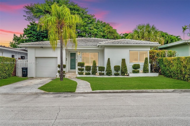 view of front facade with a lawn and a garage