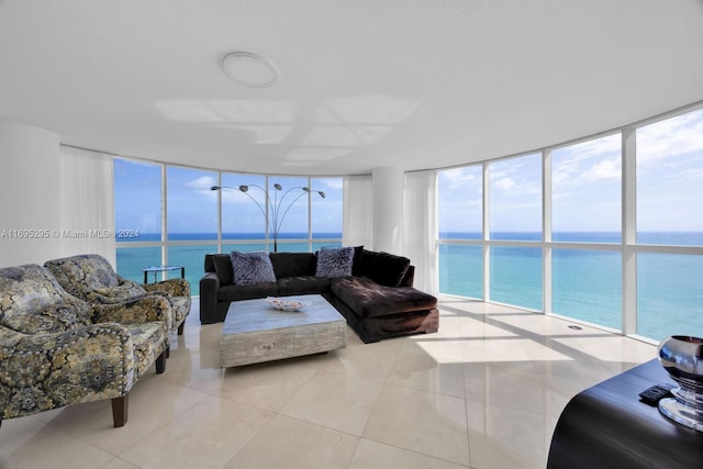 tiled living room featuring a water view and floor to ceiling windows