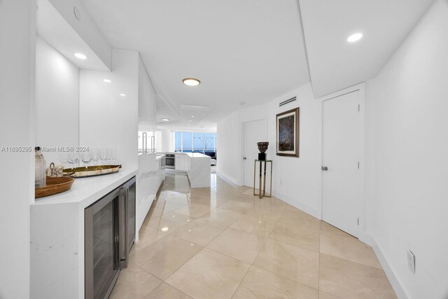 hall featuring light tile patterned flooring and beverage cooler