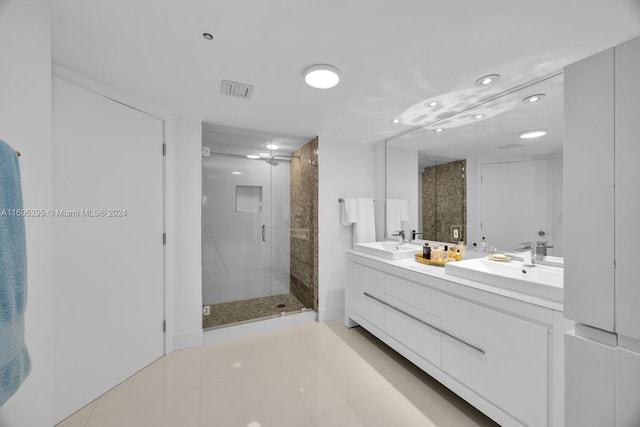 bathroom featuring a shower with door, vanity, and tile patterned flooring