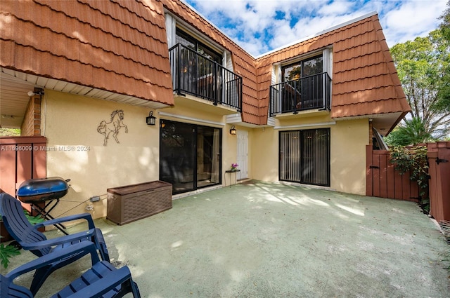 rear view of house with a balcony and a patio