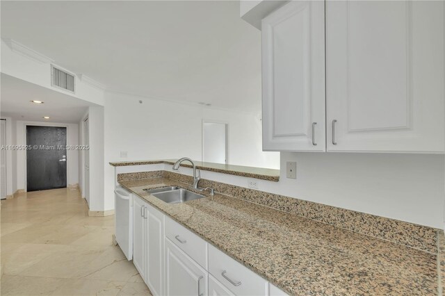 kitchen with sink, light stone counters, white dishwasher, white cabinets, and ornamental molding