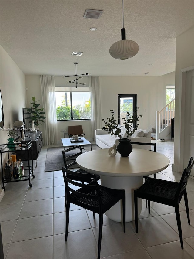 tiled dining room with a textured ceiling