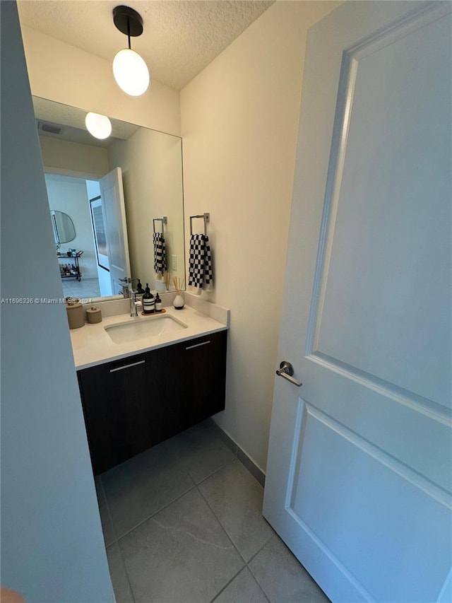 bathroom featuring a textured ceiling, vanity, and tile patterned floors