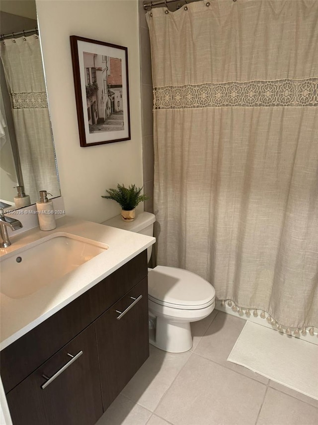 bathroom featuring tile patterned flooring, vanity, and toilet