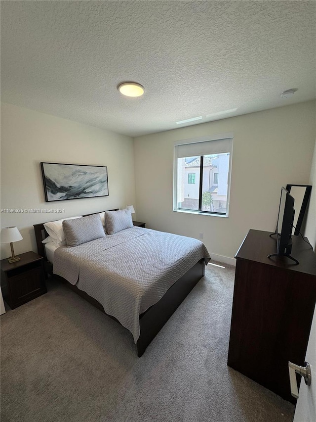 carpeted bedroom featuring a textured ceiling