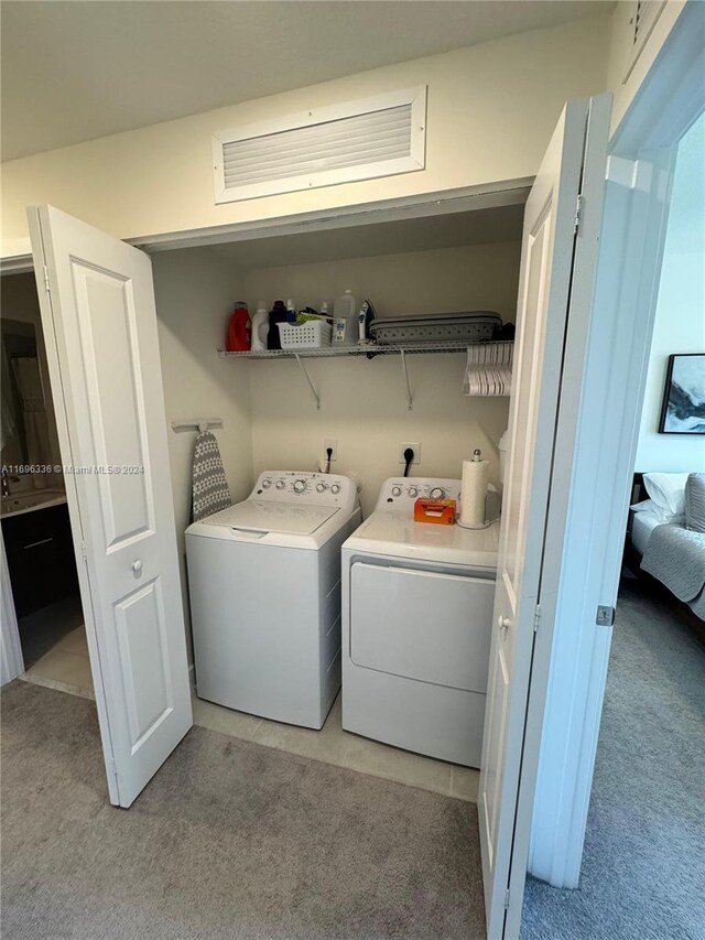 laundry room with light carpet and washing machine and clothes dryer