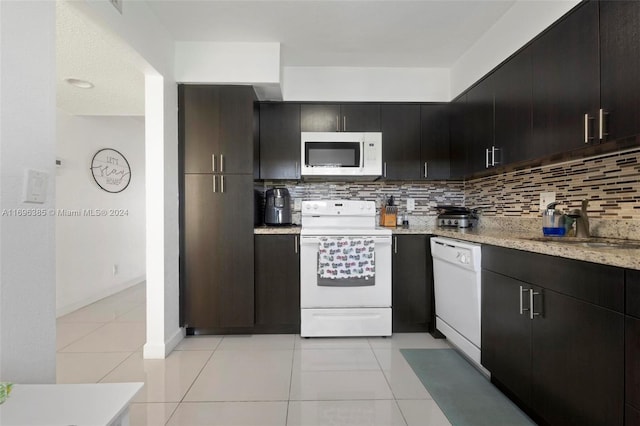 kitchen featuring tasteful backsplash, sink, light tile patterned floors, and white appliances