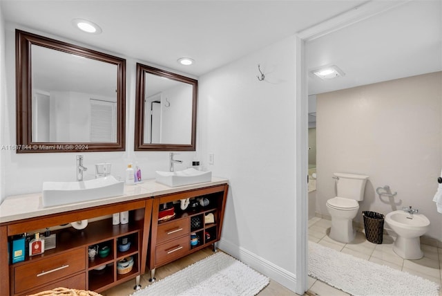 bathroom featuring tile patterned flooring, vanity, toilet, and a bidet