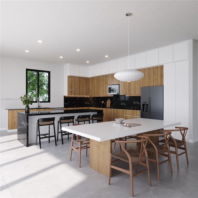 kitchen featuring white cabinets, stainless steel fridge with ice dispenser, and a kitchen island