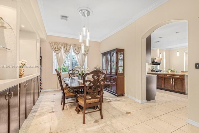 dining room with ornamental molding and light tile patterned floors