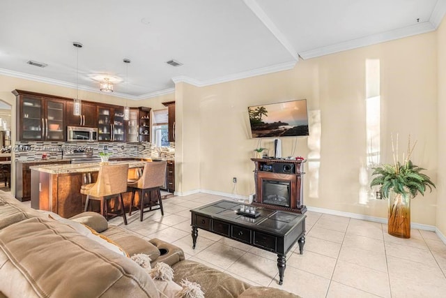 living room featuring light tile patterned floors and crown molding