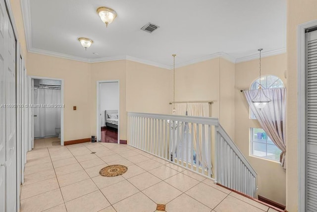 corridor featuring crown molding, plenty of natural light, and light tile patterned flooring