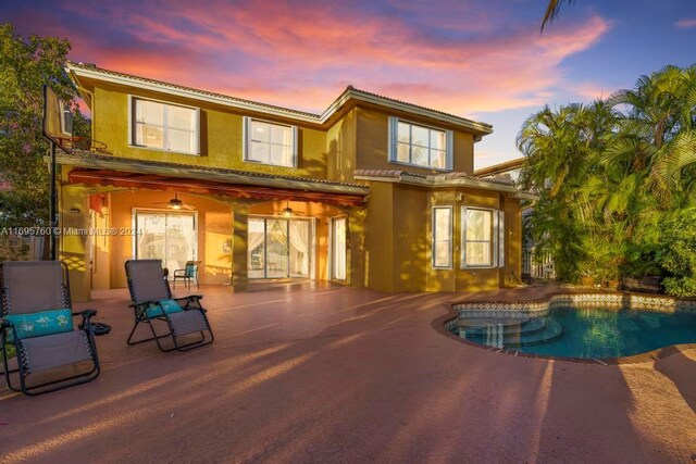 back house at dusk with a patio