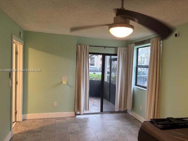 doorway to outside featuring a textured ceiling and ceiling fan