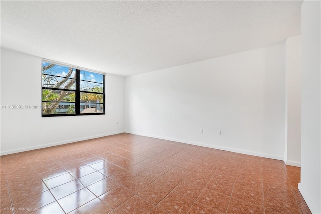 empty room with light tile patterned floors and a textured ceiling