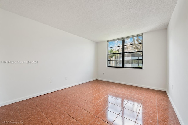 unfurnished room featuring tile patterned flooring and a textured ceiling