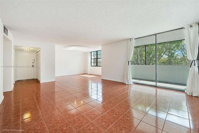 tiled spare room with a textured ceiling