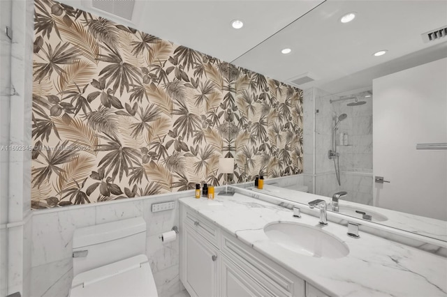 bathroom with vanity, toilet, and tiled shower