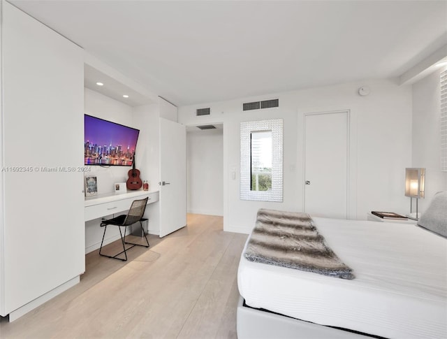 bedroom featuring hardwood / wood-style flooring and built in desk