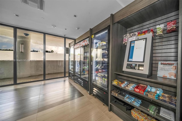 interior space with floor to ceiling windows and light wood-type flooring