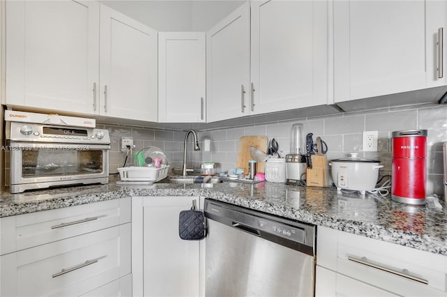 468 NE 206th Ln Unit 206, Miami, FL 33179 - kitchen with stainless steel dishwasher, white cabinets, tasteful backsplash, and light stone counters