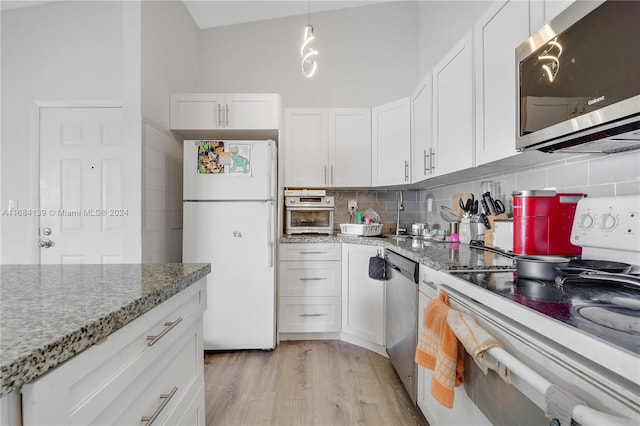 468 NE 206th Ln Unit 206, Miami, FL 33179 - kitchen with stainless steel appliances, backsplash, white cabinets, light wood-type flooring, and light stone counters