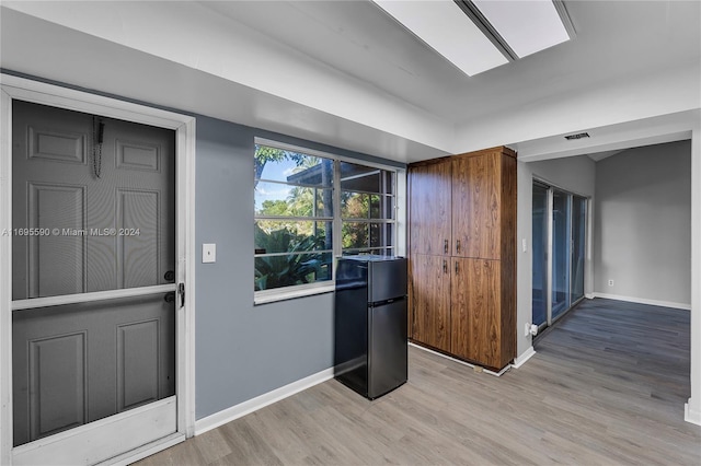 interior space featuring hardwood / wood-style floors and black refrigerator