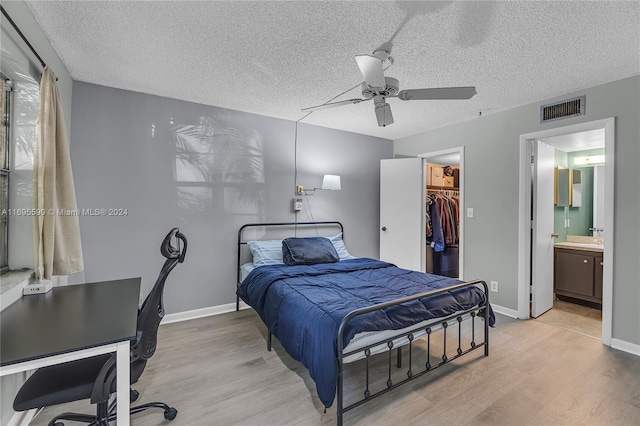 7243 W Sunrise Blvd Unit 7243K, Plantation, FL 33313 - bedroom with wood finished floors, a walk in closet, a textured ceiling, ceiling fan, and a closet
