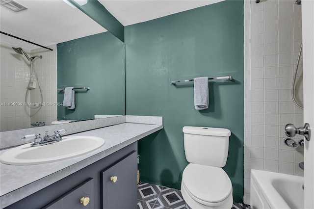 full bathroom featuring tiled shower / bath, vanity, and toilet