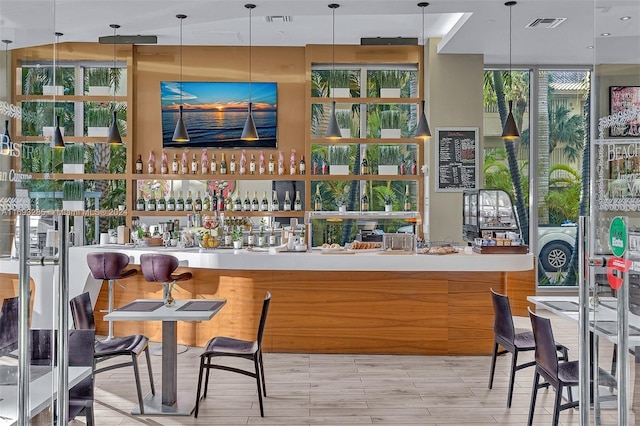 bar with floor to ceiling windows and decorative light fixtures