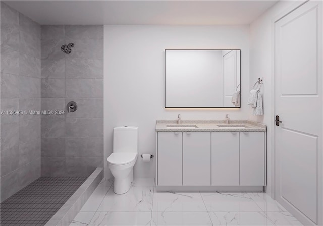 bathroom with vanity, toilet, and tiled shower